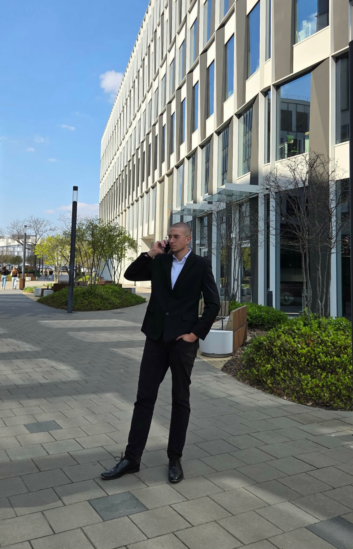 Mateusz Książyk podczas rozmowy telefonicznej przed biurowcem