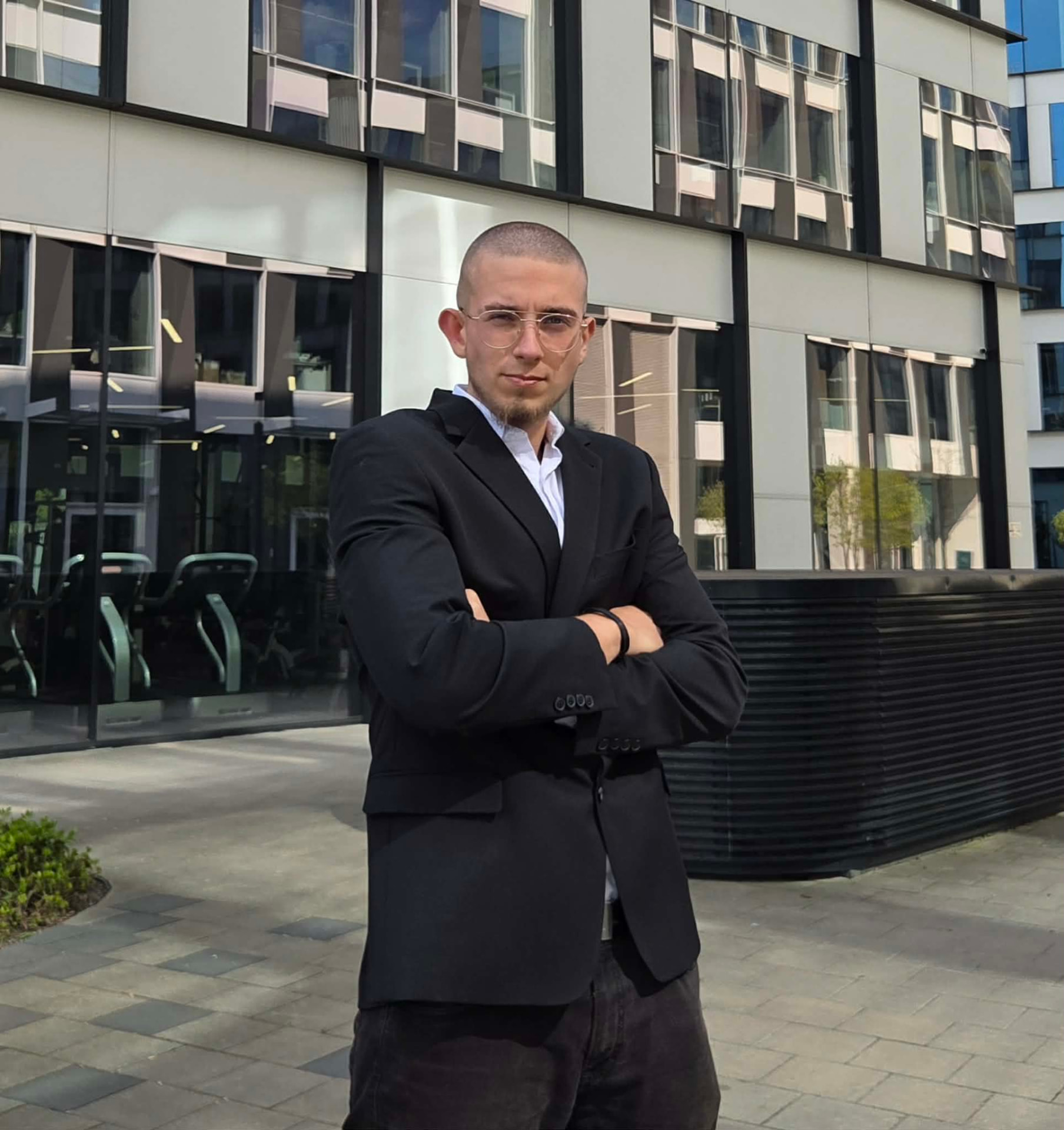 Mateusz Książyk przed biurowcem — postawa i skupienie